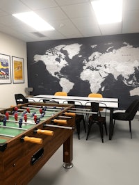 a foosball table and chairs in a room with a world map